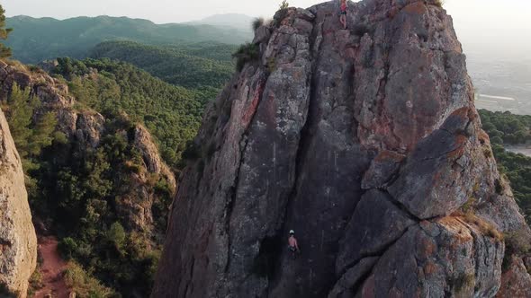 Climbing mountain in Spain. Drone aerial view of climber woman and man that climb a big rock. alt