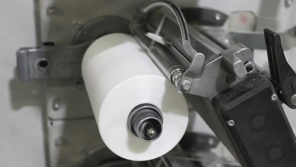 bobbin with the white thread is spinning on the machine close-up