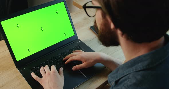 Young Man Typing on Prekeyed Laptop