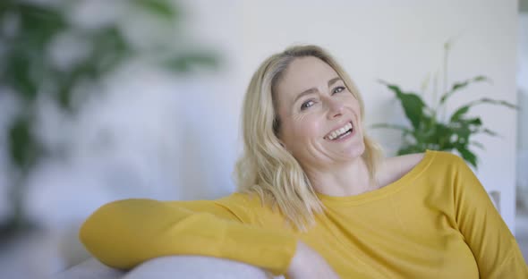 Cofident woman sitting on couch, laughing