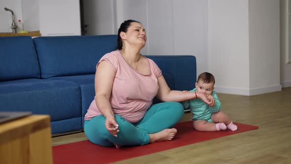 Plus Size Woman Disturbed By Her Baby While Sitting on the Floor in Meditation alt