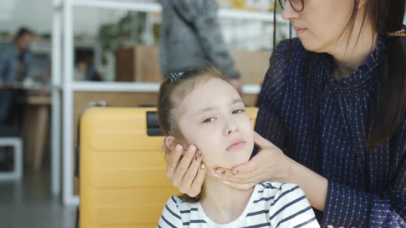 Mom Combs Her Hair a Little Cranky Daughter in the Airport Lobby Closeup