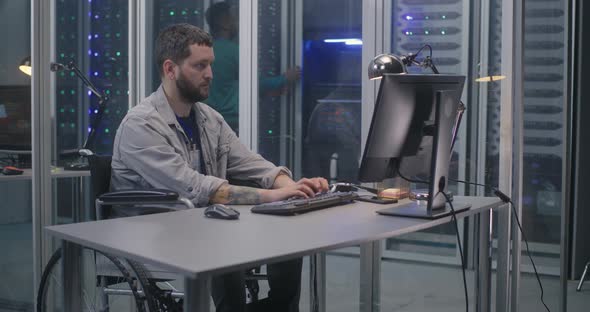 Wheelchaired Programmer Working in Data Center alt