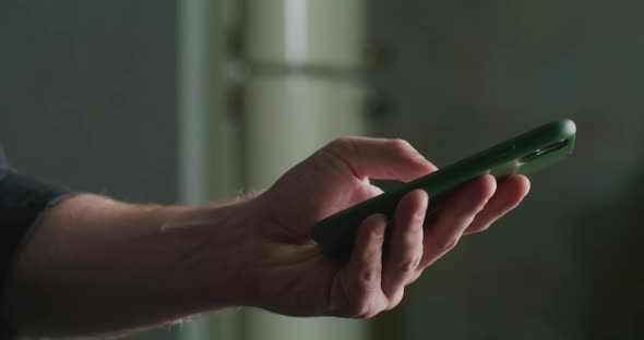 Man in a Black Shirt Sends an Email Using a Smartphone