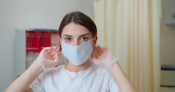 Portrait of Woman Doctor Putting on Medical Protective Face Mask