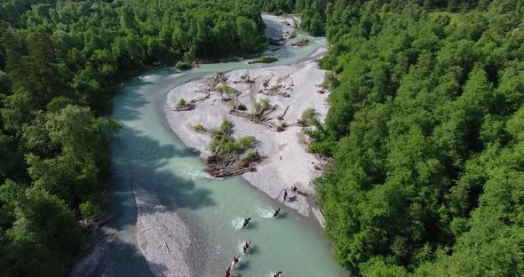 People on Horseback Cross a Mountain River  Drone Shot alt