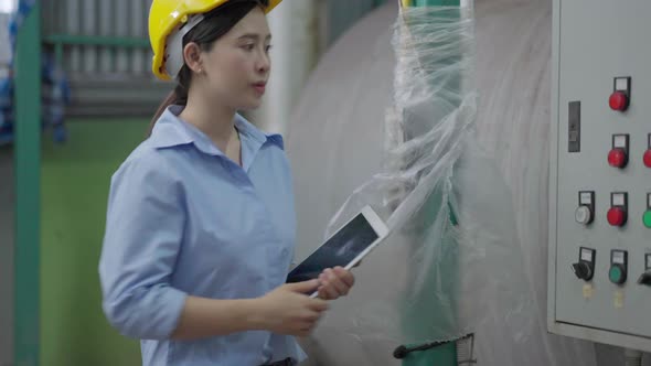 Asian female engineer worker using digital tablet checking machine performance