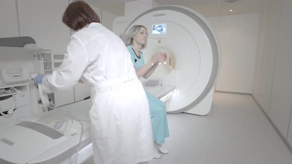 Doctor Makes an MRI Scan for a Patient in a Clinic alt
