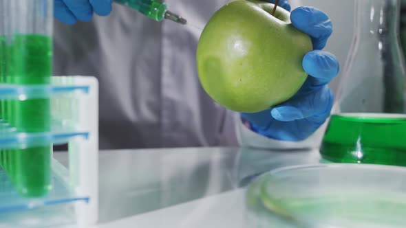 Apple in Genetic Engineering Laboratory with Syringe and Test Tubes Gmo Food Concept alt
