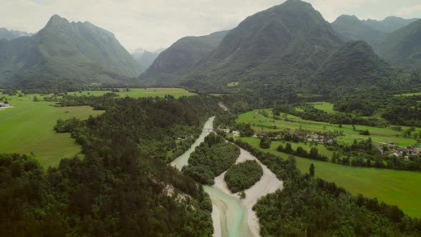 Aerial view of a small village with typical houses next to Soca river, Slovenia. alt