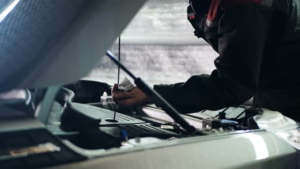 Male Mechanic Checking and Repair the Engine in Car Service alt