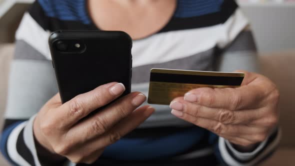 Close Up Customer Holding Credit Card and Smartphone alt