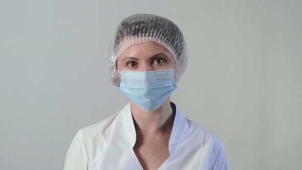 Portrait of Young Tired Caucasian Female Doctor or Nurse Wearing Medical Face Mask