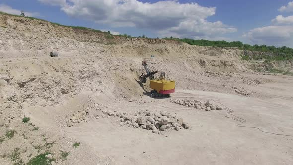 Aerial view of an excavator in a stone quarry alt