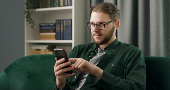 Man in Earphones Using Mobile alt