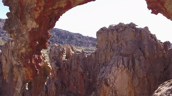 Aerial view through a rocky arch in a canyon