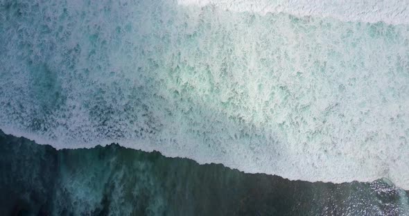 Aerial drone view of the surf and white waves breaking at the beach. alt