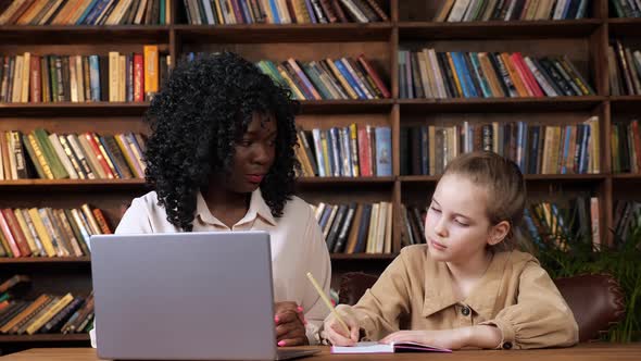 Black Lady Hugs Sad Adopted Kid Sitting at Online Lesson alt