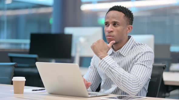 Young African Businessman with Laptop Thinking at Work alt
