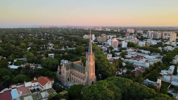 Aerial dolly out of San Isidro Cathedral and Buenos Aires city on background at sunset alt