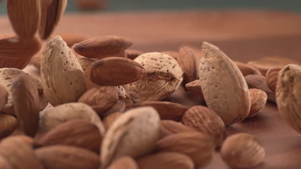 Almonds falling onto wooden surface in super slow motion.  Shot on Phantom Flex 4K high speed camera
