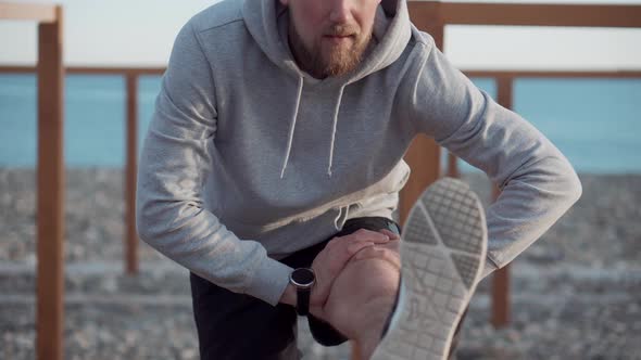 Man Is Exercising Outdoors Stretching Leg in Summer Morning alt