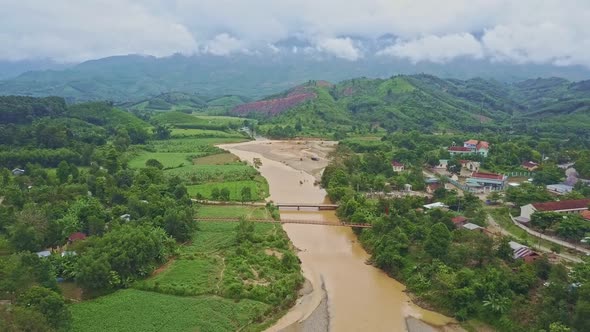 Drone Flies Along River Running Among Tropical Landscape alt