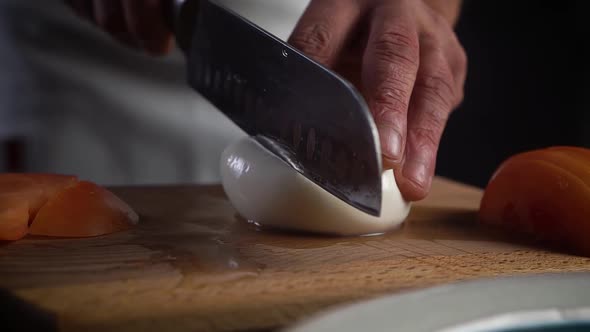 Italian Chef Cuts a Mozzarella Knife on the Board, in the Kitchen, Into Slices