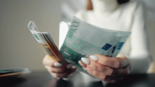 A Woman Is Holding Money and Counting Euro Bills alt