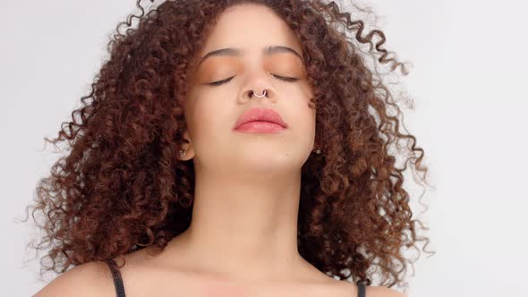 Mixed Race Black Woman with Freckles and Curly Hair Closeup Portrait with Hair Blowing