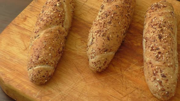 Whole-grain bread rolls on wooden cutting board