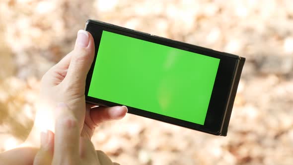 Woman outdoors  using green screen smart phone display 4K 2160p 30fps UltraHD video - Female using s