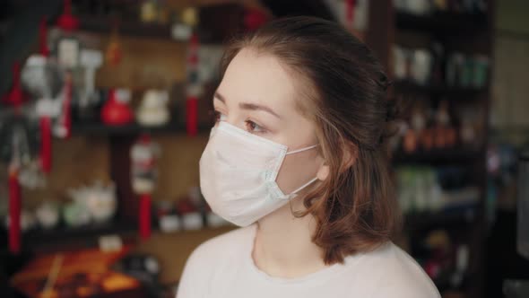 Young Student Teenager Girl in Protective Mask Standing Near Window on Home Self Isolation alt