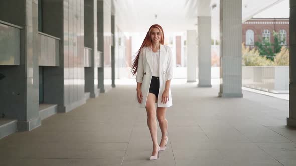 Beautiful happy woman with red hair walks and smile rejoicing in her success alt