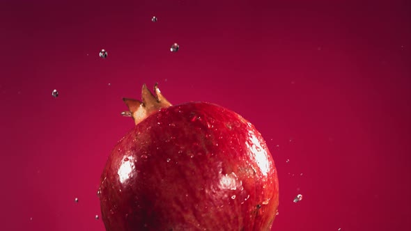 Flying of Pomegranate in Fuchsia Background in Slow Motion alt