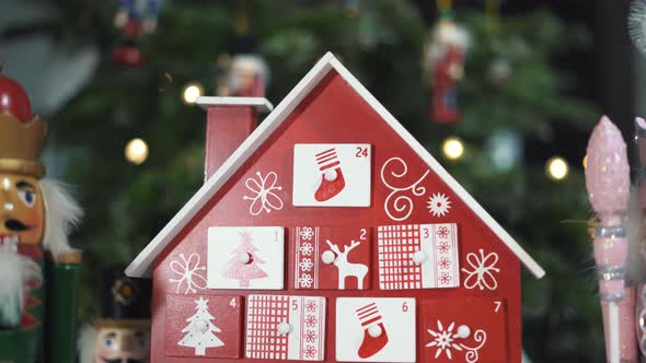 Wooden Tree Advent Calendar in Front of a Real Christmas Tree Decorated Nutcracker Soldier Toys. alt