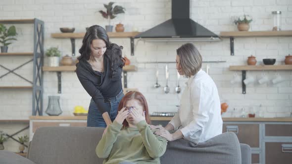 Friends Calming Down Sad Plussize Woman Sitting on Couch and Talking alt