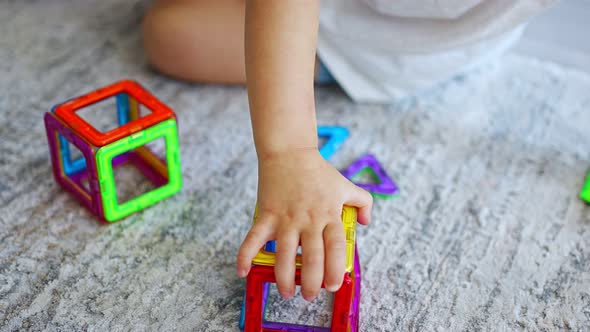 Little Girl Playing Colorful Magnet Plastic Blocks Kit at Home alt