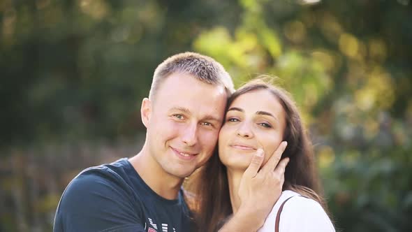 Smiling Couple Hugging and Kissing Posing Together at Summer Natural Park Close Up