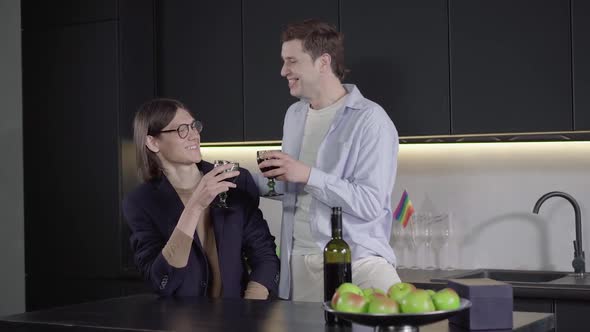 Positive Brunette Man Telling Celebratory Toast To Boyfriend in the Kitchen. Camera Approaches To alt
