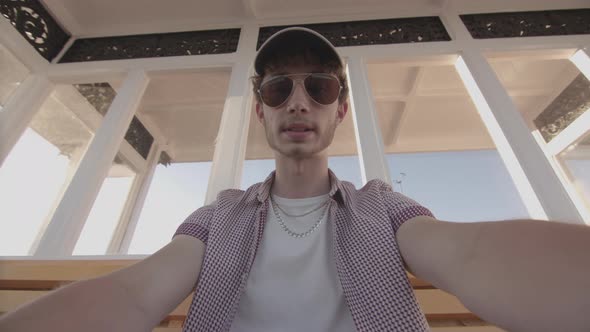 POV Man Sat On Bench At Seaside Watching Sport On His Smart Phone In Slow Motion - Ungraded alt