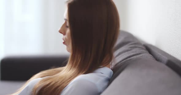 Young Woman Lies Down on the Sofa in the Living Room and Rests Peaceful Female Relaxing After Work alt