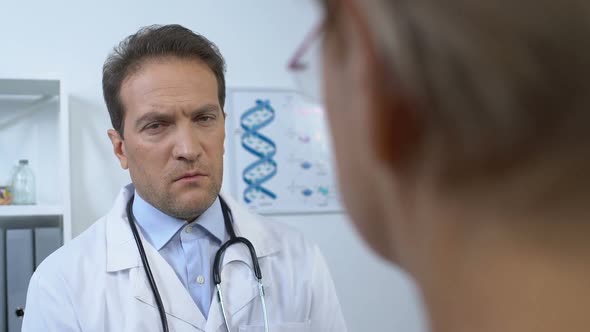 Male Therapist Listening Elderly Female Patient Symptoms, Appointment in Clinic