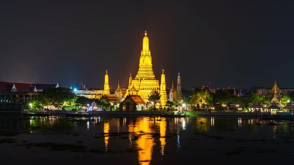 time lapse of Wat Arun Temple with Chao Phraya river at night in Bangkok, Thailand