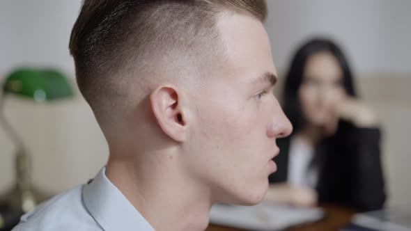 Closeup Side View of Frustrated Male Patient Talking To Blurred Psychologist alt
