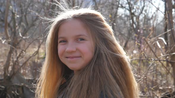 Joyful Blonde Girl Looking Into Camera and Laughing Outdoor. Portrait of Female Smiling Child alt
