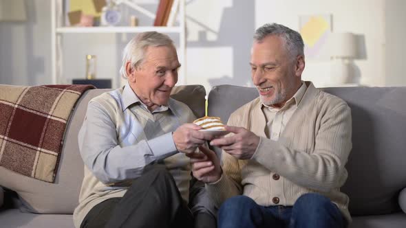 Aged Man Presenting Birthday Cake With Candle to Smiling Friend, Anniversary alt