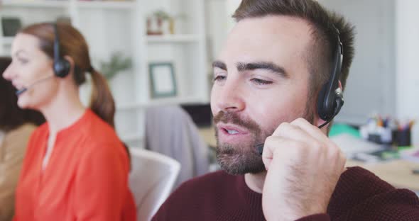 Man talking to a customer with headphone alt