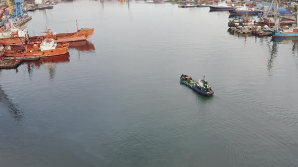 Refueling Vessel is Moving Along the Bay Among Ships Moored to the Quay Walls alt