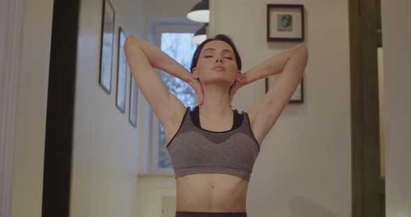 Sensual Girl in Sportive Top Bra Stretching Neck Muscles To Practice Yoga Slow Motion. Front